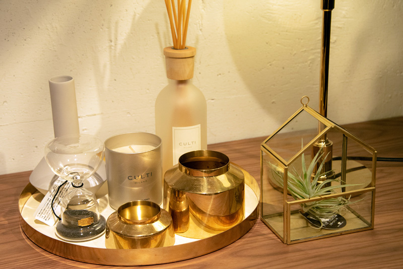 テラリウム用の家型ガラス器にエアプランツを入れて飾る。ゴールドの雑貨とカラーで統一させたおしゃれテク。